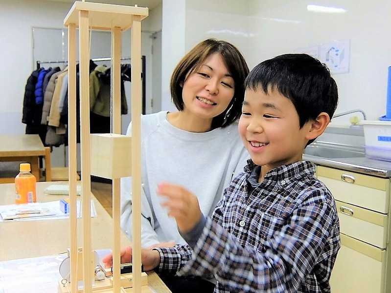 エレベーター工作を楽しむ親子の画像